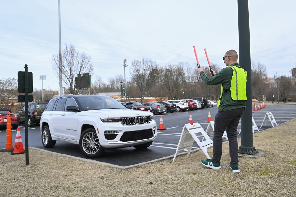 An engineering student directs guest parking.